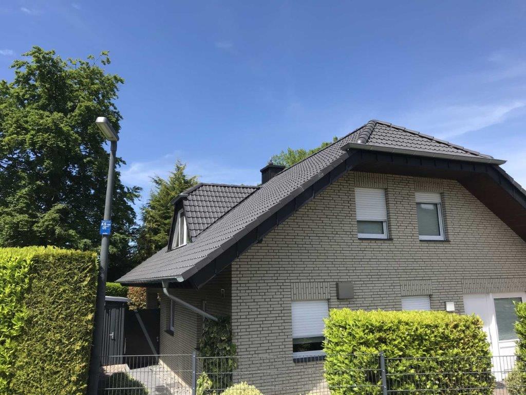 Modernes Einfamilienhaus mit Satteldach, umgeben von einem gepflegten Garten in ruhiger Wohngegend.